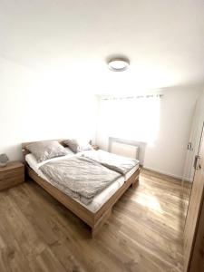 a bedroom with a bed and a wooden floor at Ferienwohnung im Zeegenbachtal in Strullendorf