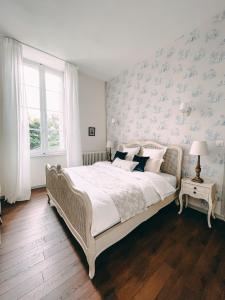 a bedroom with a large bed with blue floral wallpaper at Karma Chateau de Samary in Caux-et-Sauzens