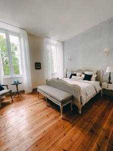 a bedroom with a large bed and wooden floors at Karma Chateau de Samary in Caux-et-Sauzens