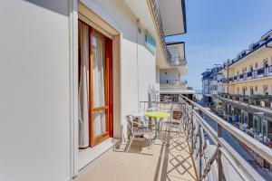 un balcone di un edificio con tavolo e sedie di Hotel Amalfi a Bellaria-Igea Marina