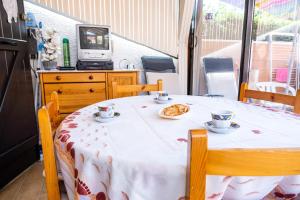 a table with two cups and a plate of food on it at Maison accueillante à Leucate avec jardin et terrasse in Leucate