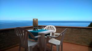 una mesa y sillas en un balcón con vistas al océano en Cota Quinta en Rio nellʼElba