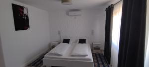 een witte kamer met 2 bedden in een kamer bij Bungalow Terra Kordu in Baile Felix