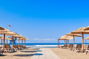 a beach with chairs and umbrellas and the ocean at Azul Beach Resort Montenegro by Karisma - All Inclusive in Ulcinj