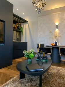 a living room with a table and a dining room at Brabant Suites in Nistelrode