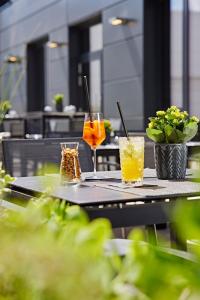 a table with two drinks on it with plants at LÉGÈRE HOTEL Erfurt in Erfurt