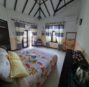 ein Schlafzimmer mit einem großen Bett und zwei Fenstern in der Unterkunft Ja-Elas French Touch in Ja-Ela