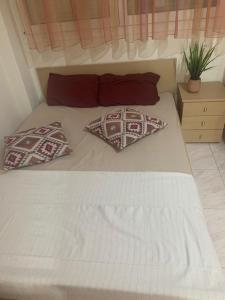 a white bed with two pillows on top of it at Elin Loft Rooms in Flogita