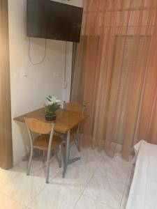 a table and chairs with a television on the wall at Elin Loft Rooms in Flogita