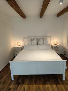 1 cama blanca en una habitación con 2 mesitas de noche en Paradies Für Zwei, en Frauenkirchen