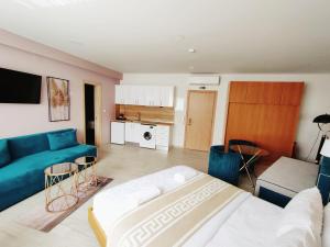 ein Wohnzimmer mit einem blauen Sofa und einer Küche in der Unterkunft La Place Suites - La Place De La Gare in Thessaloniki