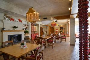 a restaurant with tables and chairs and a fireplace at Villa & Gospoda Krakowska in Kobiernice