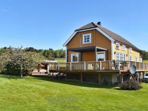 ein großes Haus mit einer großen Terrasse auf einem Rasen in der Unterkunft Holiday home Frei II in Frei