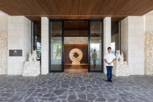 Ein Mann steht vor einem Gebäude. in der Unterkunft Hyatt Regency Seragaki Island Okinawa in Onna