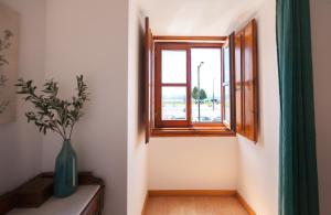 eine Vase auf einem Tisch neben einem Fenster in der Unterkunft FLH Alfama Flat with River View in Lissabon