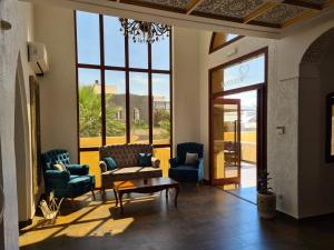 a lobby with chairs and a table and a window at Mahdia - Baghdadi - Laourient Apartments, restaurant, café in Mahdia