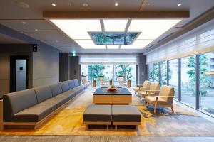 a lobby with a couch and a table and chairs at Via Inn Hakataguchi Ekimae in Fukuoka