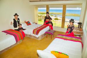 titicaca lodge - LUQUINA في Luquina: مجموعة من الأطفال يجلسون على الأسرة في غرفة النوم