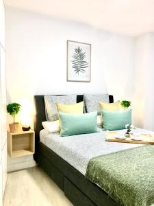 um quarto com uma cama com almofadas azuis e amarelas em Nuevo Apto B Centrico Garaje Incluido em Castro-Urdiales