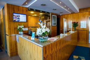 a lobby with a counter with flowers on it at Hotel Le Grand Pavois in Fécamp +37 photos