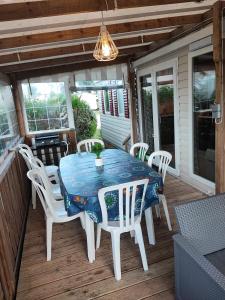 a blue table and chairs on a deck with a table and chairs at mobilhome 741 Les Charmettes in Les Mathes
