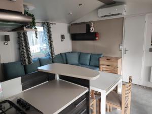 a kitchen and living room with a table and a couch at mobilhome 741 Les Charmettes in Les Mathes