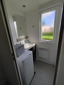 a small bathroom with a sink and a window at mobilhome 741 Les Charmettes in Les Mathes