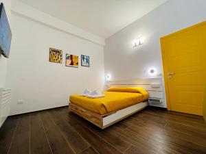 a bedroom with a yellow bed and a yellow door at B&B letterario Palazzo Pistocchi in Teramo