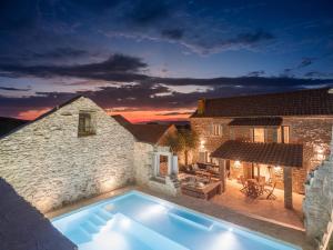 a villa with a swimming pool in front of a house at Casa M Hvar in Zastražišće