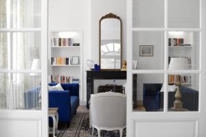 a living room with a blue couch and a mirror at Karma Chateau de Samary in Caux-et-Sauzens