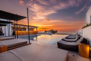 a villa with a pool with a sunset in the background at Atermono Boutique Resort & Spa in Platanes