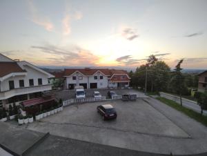 a car parked in a parking lot in front of houses at Loznica, Venera sobe in Ploča