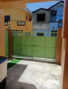 a green gate in front of a house at Paniqui, Tarlac - Madrid in Anao