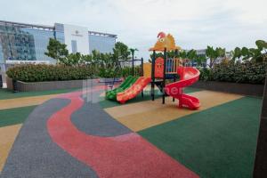 um parque infantil com escorrega num parque em Redliving Apartemen Sayana - Hazelnut Property Tower Cha em Penggarutan