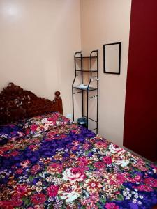 a bed with a colorful bedspread with flowers on it at Paniqui, Tarlac - Madrid in Anao
