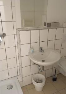 W łazience znajduje się umywalka, toaleta i lustro. w obiekcie SITE.INN Hamburg w mieście Hamburg