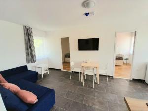 a living room with a blue couch and a table at Sóstói Strand Apartmanház in Siófok