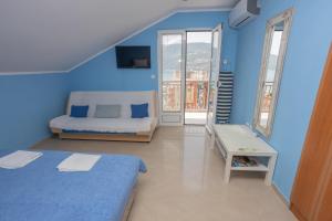 a blue room with a bed and a couch at Adriana Apartments in Herceg-Novi
