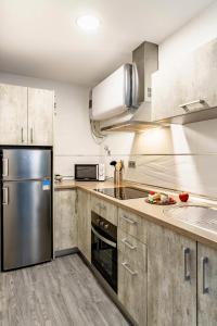 una cocina con nevera de acero inoxidable y armarios en My Granada Garden - Mimosa studio, en Granada