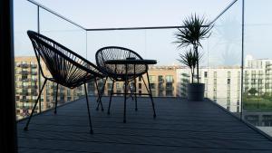 a pair of chairs and a table on a balcony at Luxury 1-Bed Apartment with River and City view in London