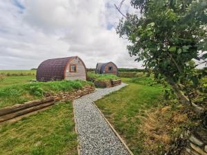 an image of two barns in a field at Glamping Pods Nr Port Isaac in Port Isaac