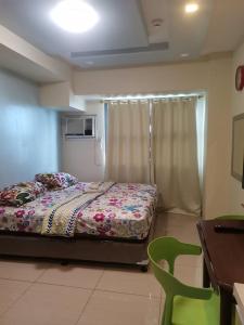 a bedroom with a bed and a desk and a chair at HORIZON 101 A4 near robinson mall Free POOL WIFI in Cebu City