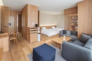 a hotel room with a bed and a couch at MUJI HOTEL GINZA in Tokyo