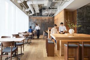 MUJI HOTEL GINZA في طوكيو: مجموعة من الناس يجلسون على الطاولات في المطعم