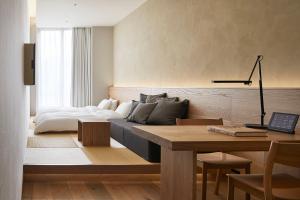 a living room with a bed and a table at MUJI HOTEL GINZA in Tokyo