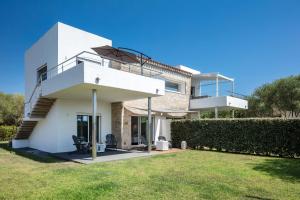 a white house with a lawn in front of it at Sardegna é - Villa Charme&Design in Olbia