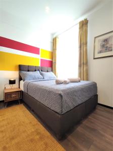 a bedroom with a bed and a colorful wall at Intimate Studios Hadersdorf in Hadersdorf am Kamp