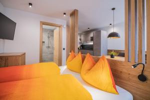 a bedroom with yellow and orange pillows on a bed at Kuenz Dolomites App 2 in San Candido