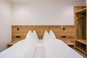 a bedroom with two beds with white sheets at Kuenz Dolomites App 4 in San Candido
