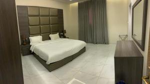 a bedroom with a large bed with a large headboard at روز الخيال للشقق المخدومة 2 in Al Kharj